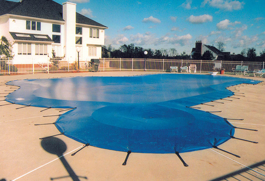 Bright blue mesh pool cover stretched over a circular swimming pool.