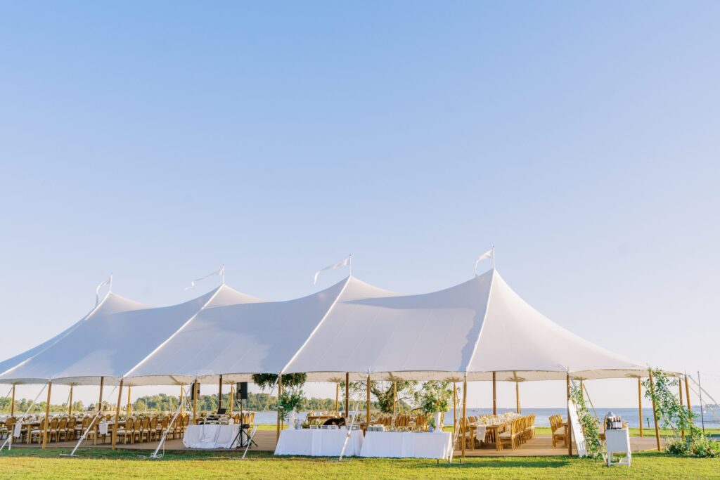 Large white sailcloth tent with open sides for an elegant event.