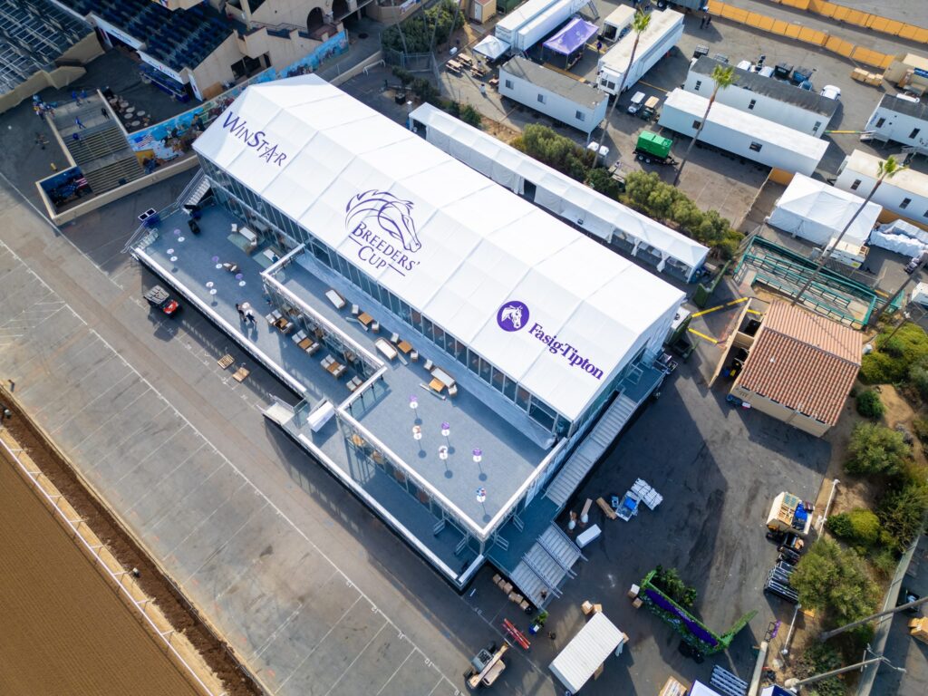 Aerial view of a large white industrial tent building in a commercial area.