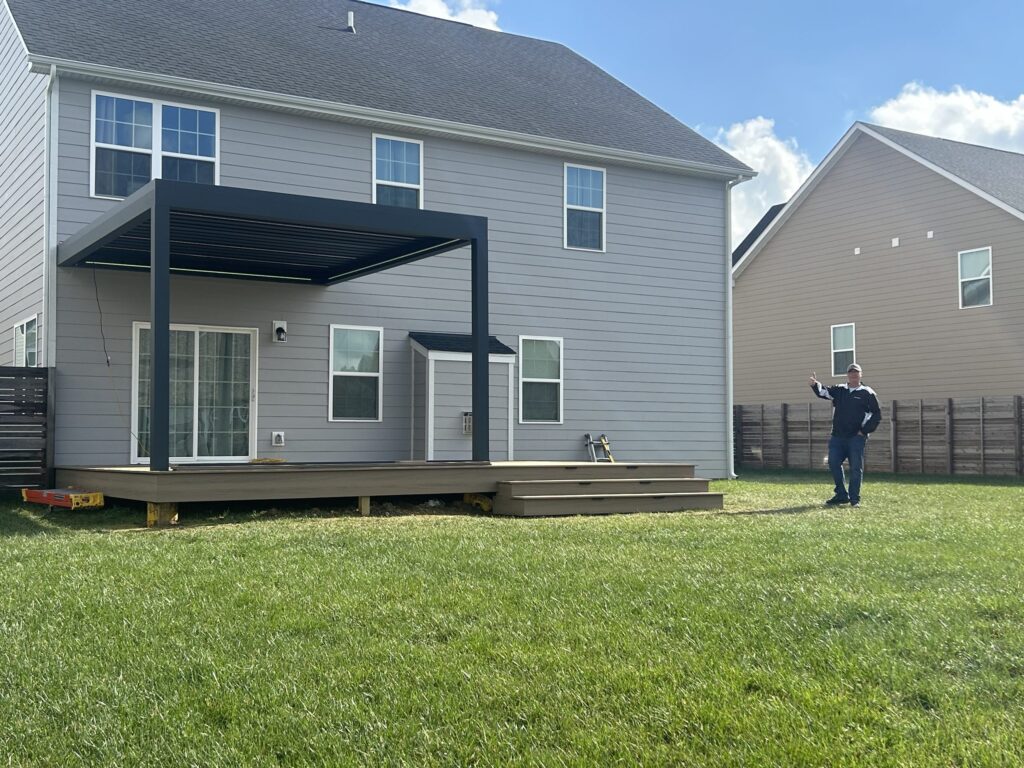 Beautiful backyard pergola decorated with plants, fabrics, and lights for outdoor living.