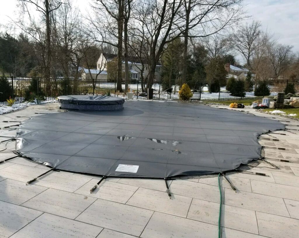 mesh-defender: pool protected by a gray mesh safety cover.