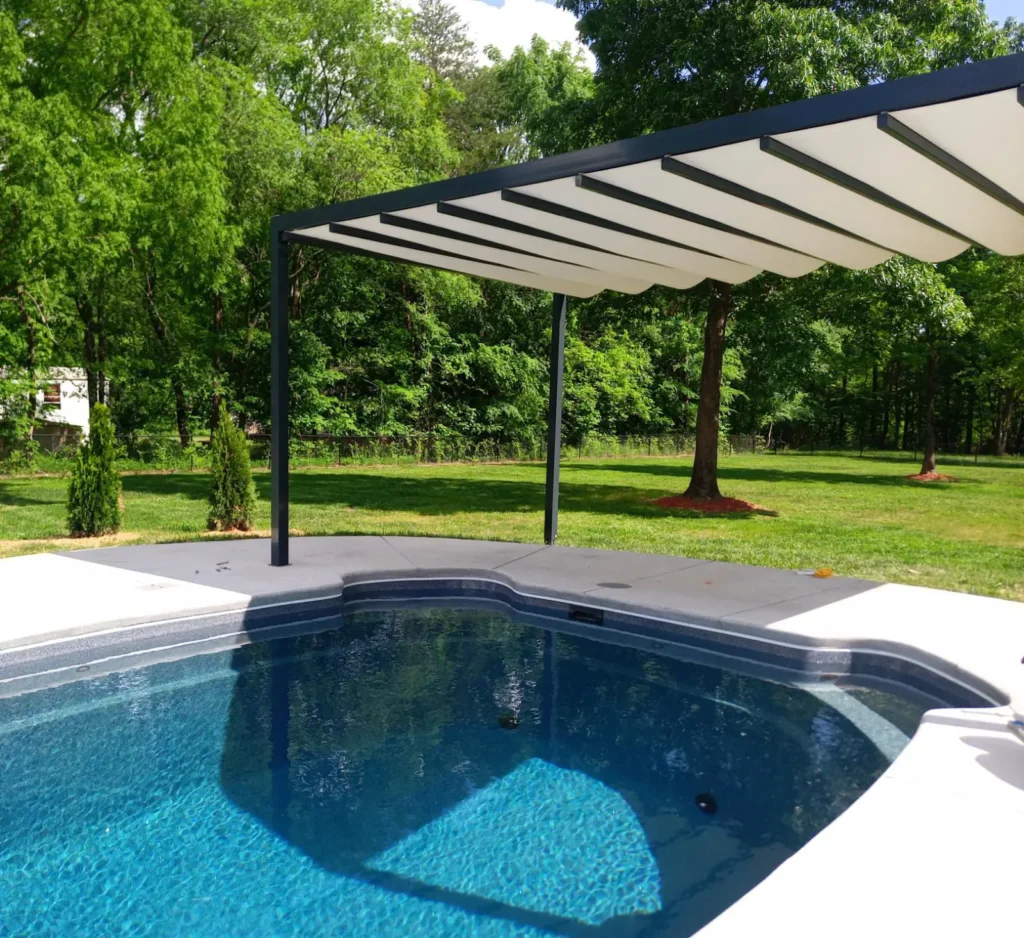 Modern pergola shade structure beside outdoor swimming pool in backyard