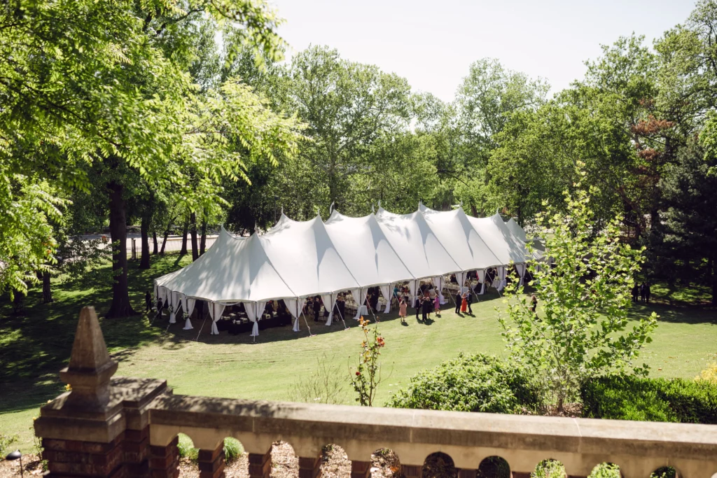 Long white Anchor Industries pole tent in wooded outdoor event space