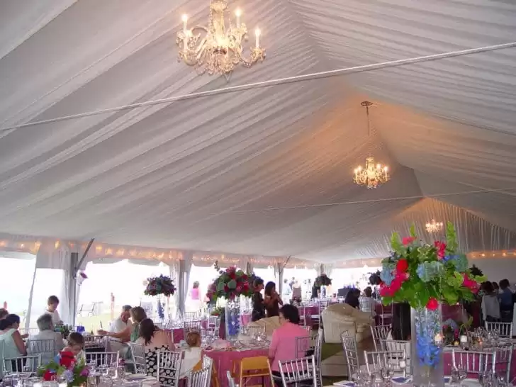 Wedding tent with chandeliers – elegant white marquee with chandeliers and banquet tables.