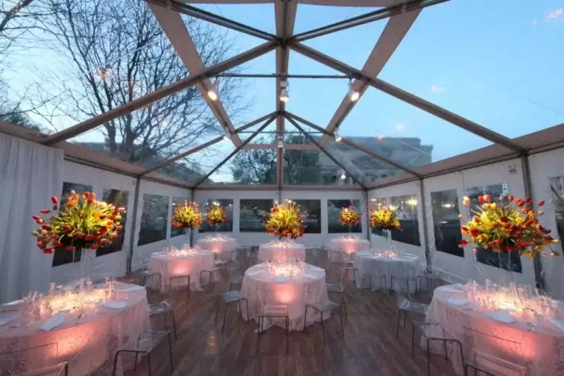 Transparent tent with chandeliers – clear roof marquee setup with dining tables and lighting.