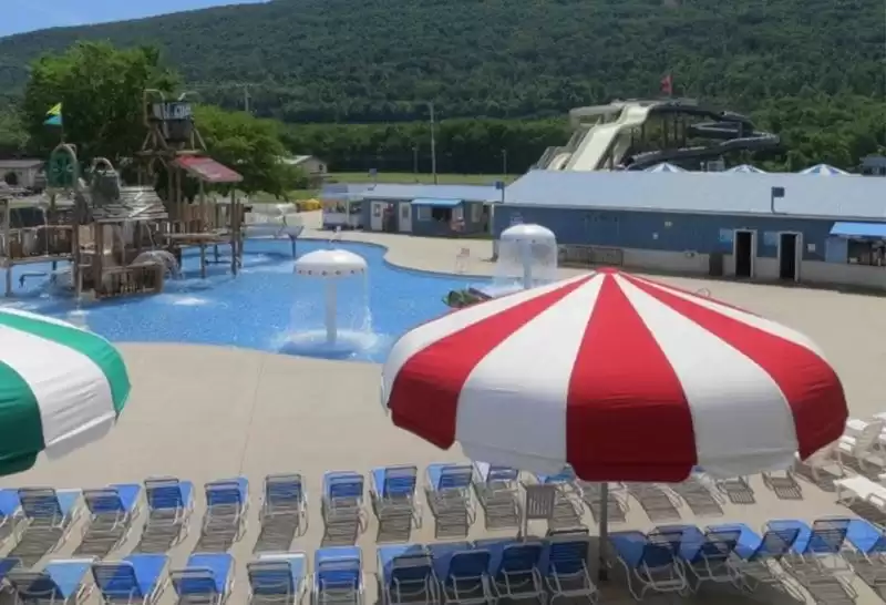 Anchor Industries red and white striped umbrella at resort pool