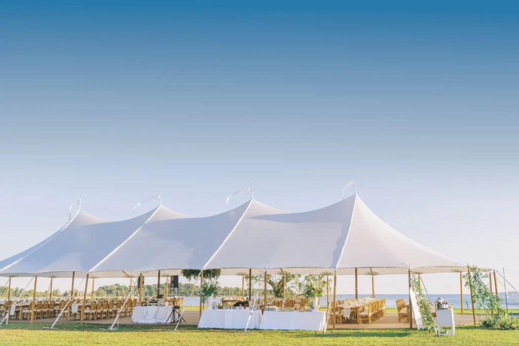 White high peak wedding tent by Anchor Industries on grass field