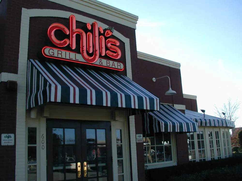 Restaurant exterior with black and white striped awning.