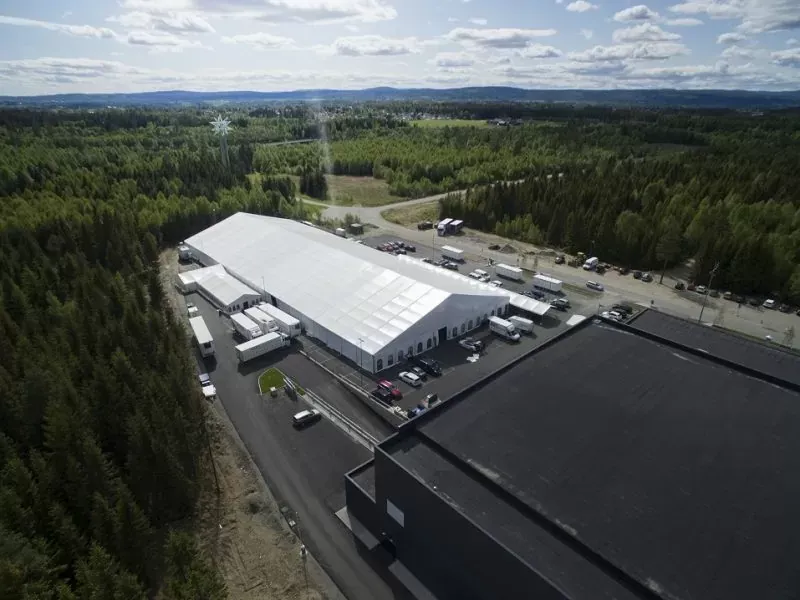 Large white tension structure on an industrial site viewed from above.
