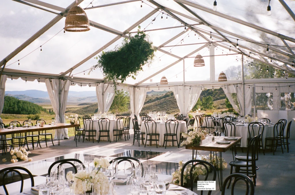Clear top frame tent with elegant interior setup and hanging greenery