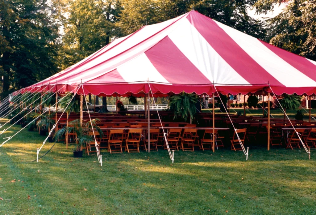 Anchor Industries red and white striped pole tent with seating inside