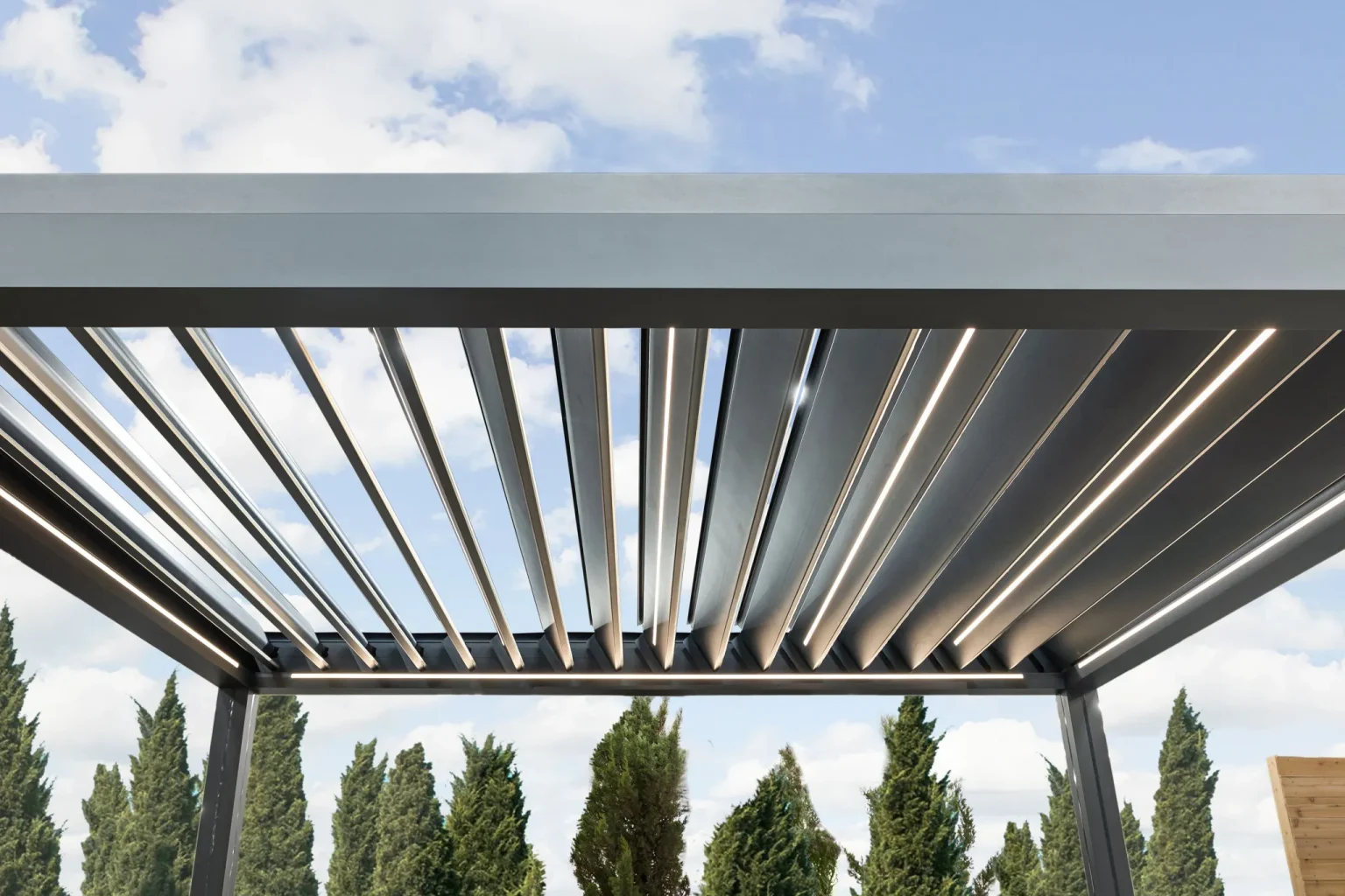 Close-up of louvered pergola roof panels showing light and shadow patterns.