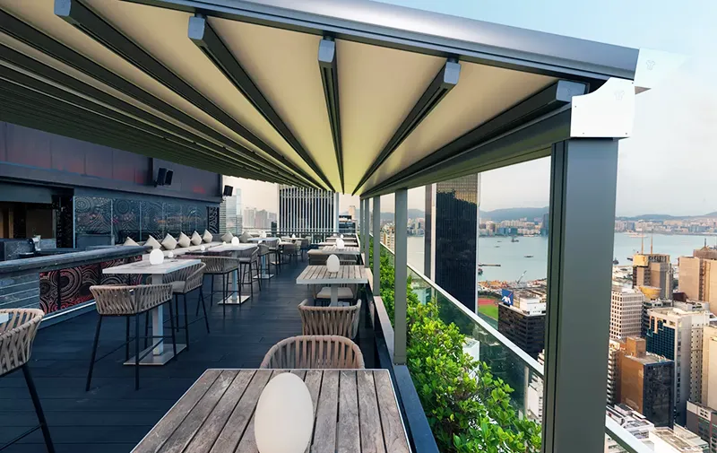 Rooftop dining area with modern metal pergola and seating.