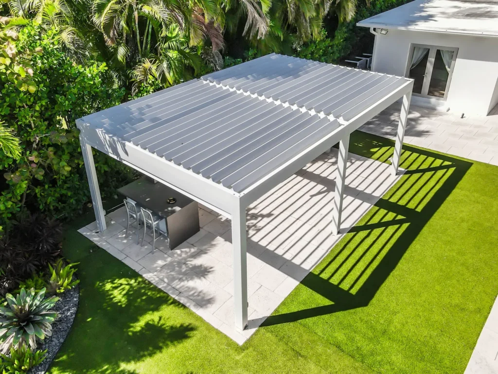 Modern aluminum pergola with adjustable louvers over a garden patio.