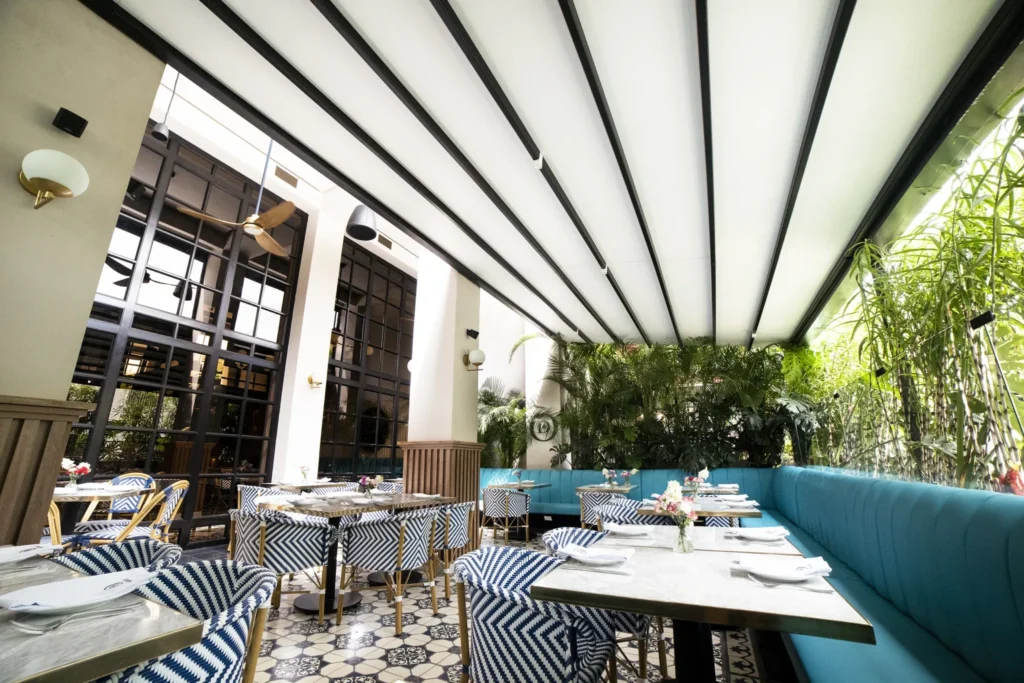 Retractable roof pergola shading an elegant outdoor restaurant area.