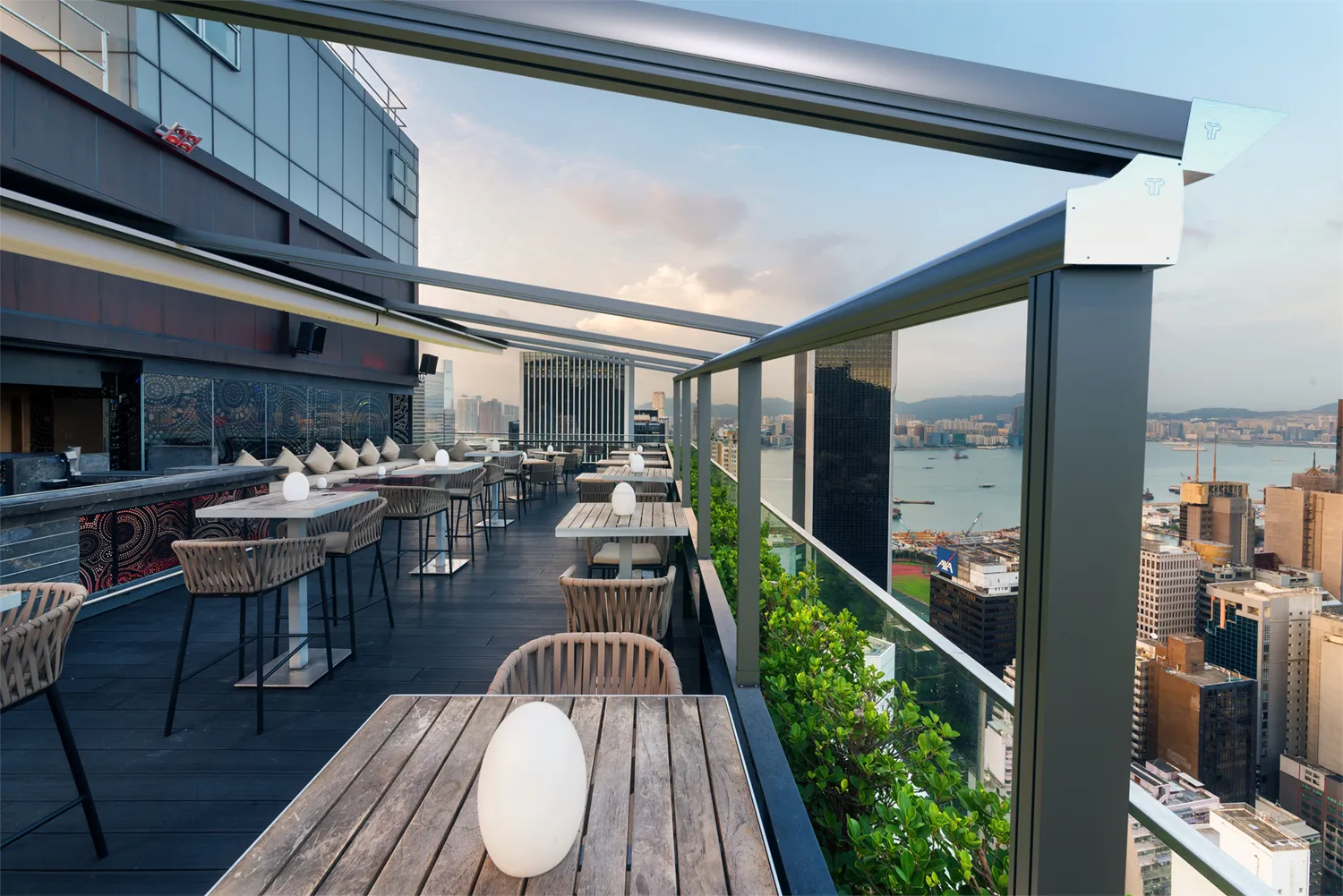 Modern rooftop terrace with metal pergola and city view.