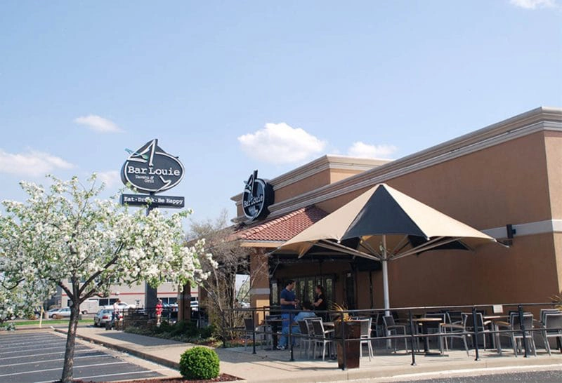 Restaurant patio with fixed awning providing shaded seating.