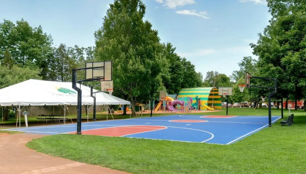 Small playground area with tents and basketball court nearby.