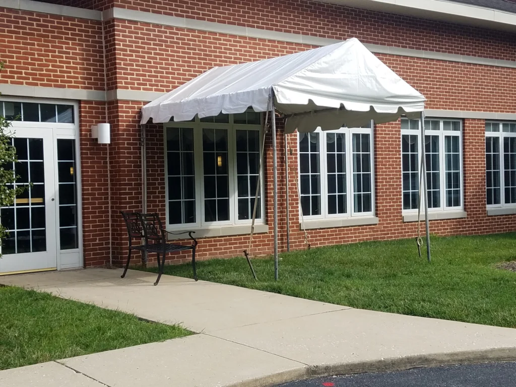 Small white entrance canopy attached to brick commercial building