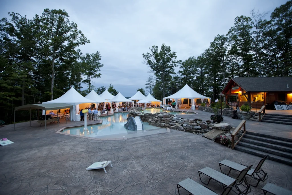 Poolside setup with multiple white frame tents and lounge seating