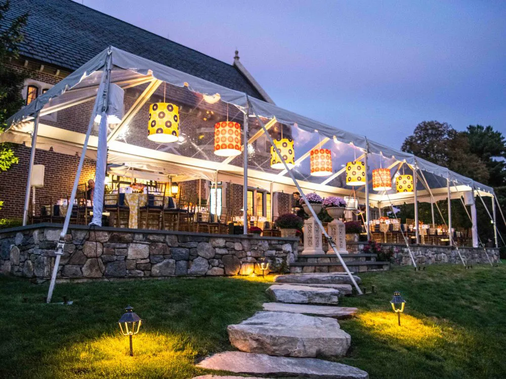 Outdoor dining patio with illuminated canopy and evening lighting.