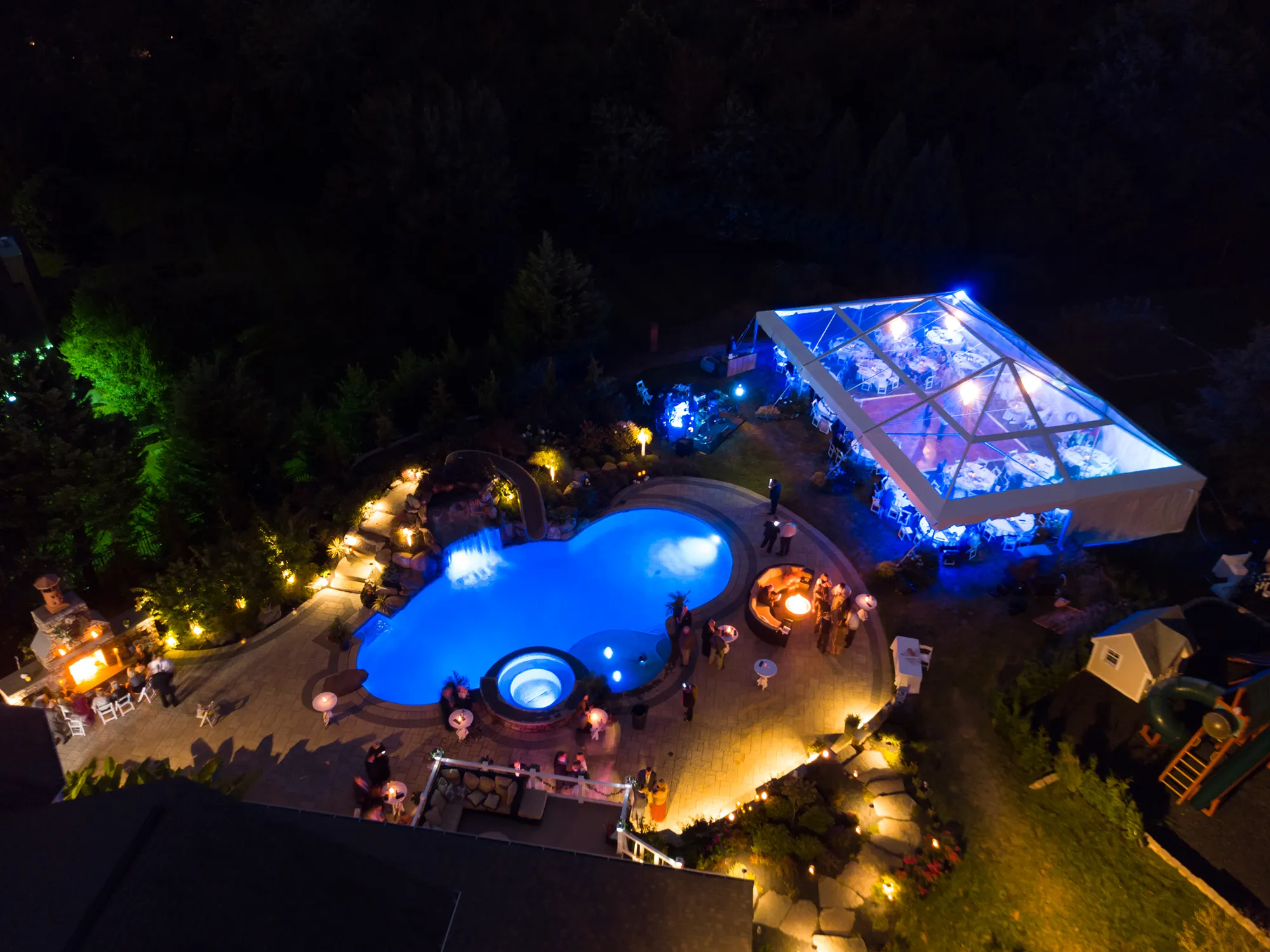 Night aerial view of a property with illuminated event tents.