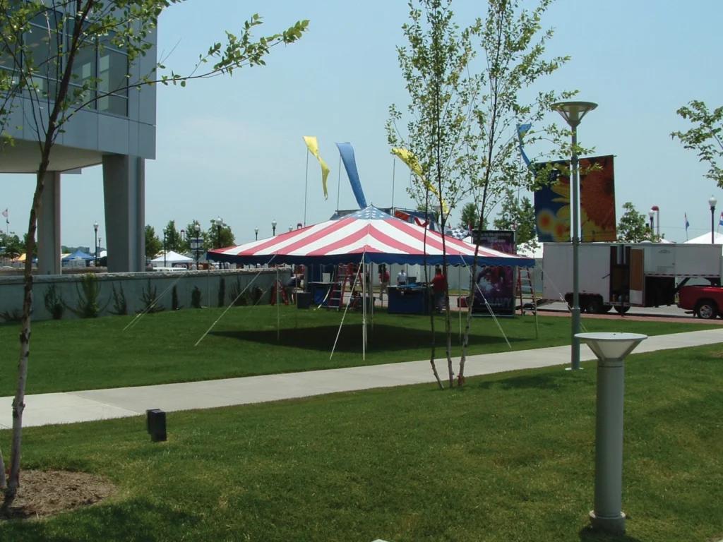 Red and white striped Anchor Industries event tent on grass field
