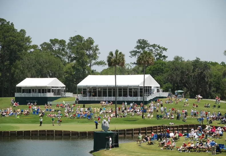 Large white event tent set up beside a pond during an outdoor festival.